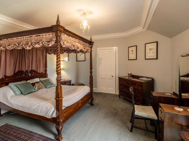One of the 13 bedrooms, many of which have an array or original features including ornate cornicing and plasterwork, open fires and tall ceilings.