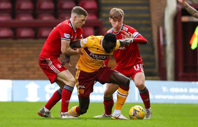 Motherwell's Bevis Mugabi in action alongside Lewis Ferguson and Aberdeen's Adam Montgomerey.