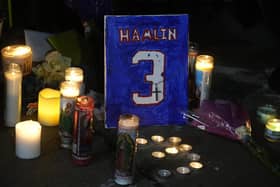A painting that shows the number of Buffalo Bills' Damar Hamlin is illuminated by candles during a prayer vigil outside University of Cincinnati Medical Center, Tuesday, Jan. 3, 2023, in Cincinnati.