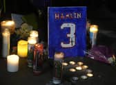 A painting that shows the number of Buffalo Bills' Damar Hamlin is illuminated by candles during a prayer vigil outside University of Cincinnati Medical Center, Tuesday, Jan. 3, 2023, in Cincinnati.