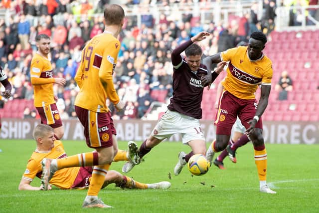 Hearts' Cammy Devlin is tackled by Motherwell's Juhani Ojala (left) during the 2-0 win at Tynecastle (Photo by Sammy Turner / SNS Group)
