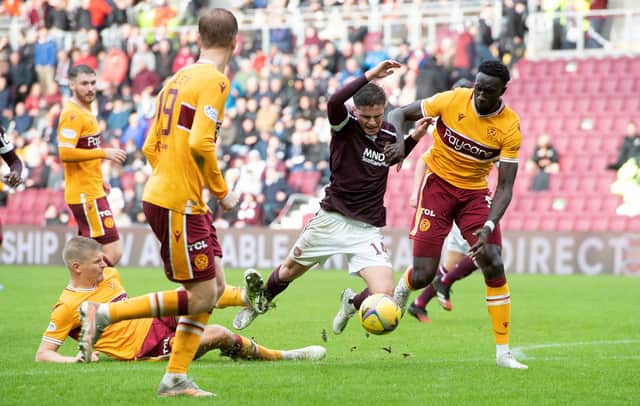 Hearts' Cammy Devlin is tackled by Motherwell's Juhani Ojala (left) during the 2-0 win at Tynecastle (Photo by Sammy Turner / SNS Group)