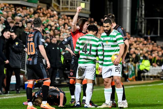 Celtic's Reo Hatate is shown a yellow card by John Beaton for a challenge on Dundee United's Kieran Freeman. (Photo by Rob Casey / SNS Group)