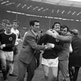 Scotland's Jim Baxter is hugged by fans who invaded the pitch at Wembley following the 3-2 victory over England in 1967.