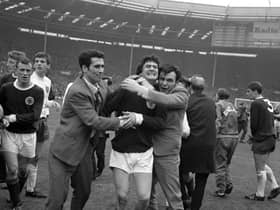 Scotland's Jim Baxter is hugged by fans who invaded the pitch at Wembley following the 3-2 victory over England in 1967.