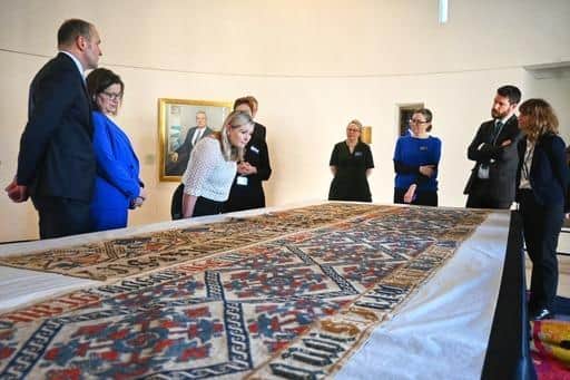 Guðni Jóhannesson inspects a tapestry at National Museums Scotland, which was taken from Iceland in the 1800s after being bought by a Scottish tourist.