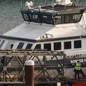 Migrants picked up at sea while attempting to cross the English Channel are escorted off from a UK Border Force boat upon arrival at the Marina in Dover, southeast England, last year.