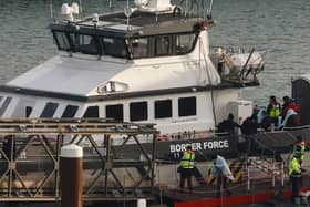 Migrants picked up at sea while attempting to cross the English Channel are escorted off from a UK Border Force boat upon arrival at the Marina in Dover, southeast England, last year.