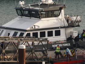 Migrants picked up at sea while attempting to cross the English Channel are escorted off from a UK Border Force boat upon arrival at the Marina in Dover, southeast England, last year.