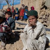 Afghan boys sit outside newly built houses constructed by the United Nations refugee agency (UNHCR) in Barmal district, Paktika province, following humanitarian work. Picture: AFP via Getty Images