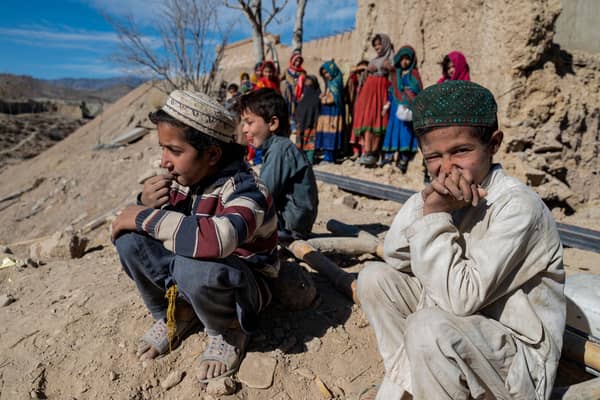 Afghan boys sit outside newly built houses constructed by the United Nations refugee agency (UNHCR) in Barmal district, Paktika province, following humanitarian work. Picture: AFP via Getty Images