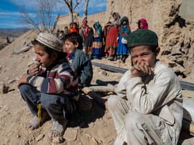 Afghan boys sit outside newly built houses constructed by the United Nations refugee agency (UNHCR) in Barmal district, Paktika province, following humanitarian work. Picture: AFP via Getty Images