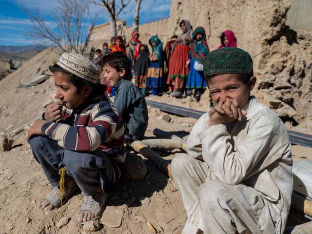 Afghan boys sit outside newly built houses constructed by the United Nations refugee agency (UNHCR) in Barmal district, Paktika province, following humanitarian work. Picture: AFP via Getty Images