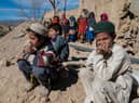 Afghan boys sit outside newly built houses constructed by the United Nations refugee agency (UNHCR) in Barmal district, Paktika province, following humanitarian work. Picture: AFP via Getty Images