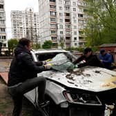 A car hit by the remains of a Russian drone shot down over the Ukrainian capital Kyiv is loaded onto a truck (Picture: Sergei Chuzavkov/AFP via Getty Images)