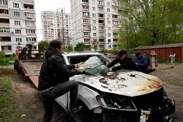 A car hit by the remains of a Russian drone shot down over the Ukrainian capital Kyiv is loaded onto a truck (Picture: Sergei Chuzavkov/AFP via Getty Images)