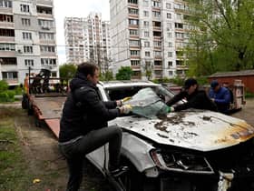 A car hit by the remains of a Russian drone shot down over the Ukrainian capital Kyiv is loaded onto a truck (Picture: Sergei Chuzavkov/AFP via Getty Images)