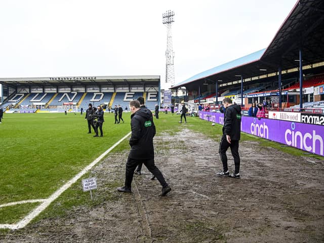 Officials walk onto the pitch to conduct an inspection of Dens Park - the Dundee v Rangers match was eventually called off.
