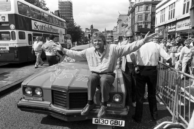 British businessman Richard Branson poses with his pink Pontiac car outside his new Virgin Megastore, opening in Edinburgh in July 1990.