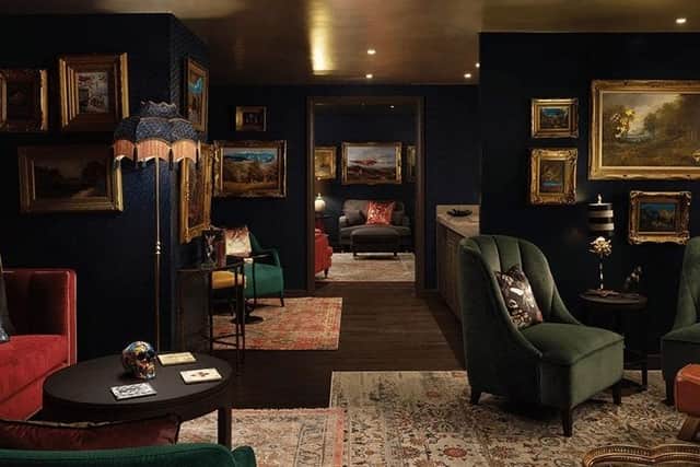 There is an opulent mix of dark walls, gold-framed artwork, and chairs and sofas upholstered in rich jewel-coloured fabrics throughout the property. Pic: Contributed