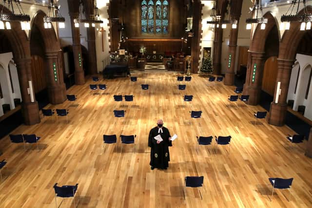 Dr Browning d holds the Christmas day order of service, as he puts them on socially distanced chairs inside Morningside Parish Church