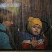 A child greets from the window of a bus after crossing the Ukrainian border with Poland at the Medyka border crossing