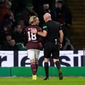 Referee Bobby Madden with Hearts winger Barrie McKay after he is hit with objects from the Celtic support last Thursday.