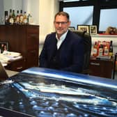 Dundee managing director John Nelms with a render of Dundee’s Camperdown Stadium.