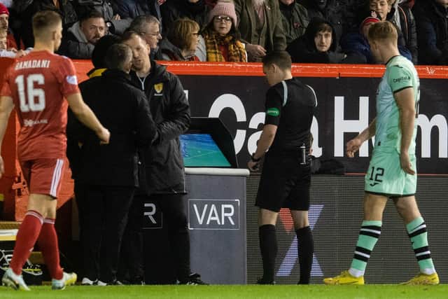 Referee David Munro looks at the VAR monitor before awarding Aberdeen a penalty which led to their opener in the 4-1 win over Hibs.  (Photo by Craig Foy / SNS Group)