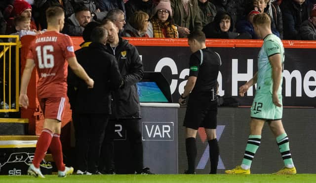 Referee David Munro looks at the VAR monitor before awarding Aberdeen a penalty which led to their opener in the 4-1 win over Hibs. (Photo by Craig Foy / SNS Group)