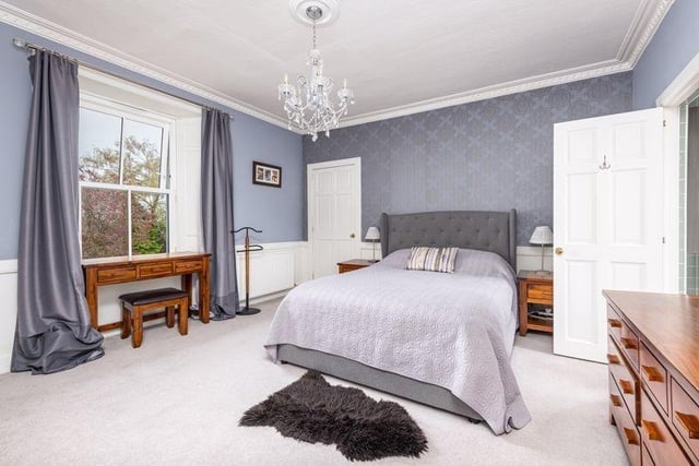The principal bedroom is fitted with double wardrobes, a single cupboard, and a walk-in dressing area.