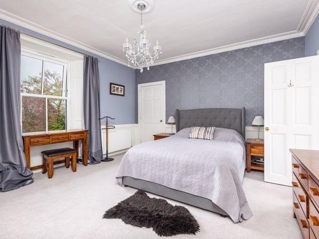 The principal bedroom is fitted with double wardrobes, a single cupboard, and a walk-in dressing area.