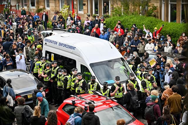 Protesters block a UK Home Office van to stop it from leaving Kenmure Street in Glasgow (Picture: Jeff J Mitchell/Getty Images)