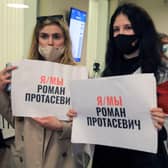 Women with posters reading 'I am/we are Roman Protasevich' in the arrival area as passengers disembark from the Ryanair passenger plane from Athens that was intercepted and diverted to Minsk on the same day by Belarus authorities on 23 May (Photo: PETRAS MALUKAS/AFP via Getty Images)