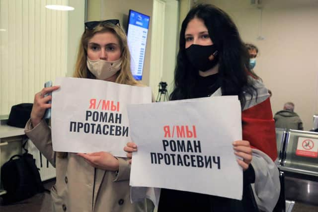 Women with posters reading 'I am/we are Roman Protasevich' in the arrival area as passengers disembark from the Ryanair passenger plane from Athens that was intercepted and diverted to Minsk on the same day by Belarus authorities on 23 May (Photo: PETRAS MALUKAS/AFP via Getty Images)