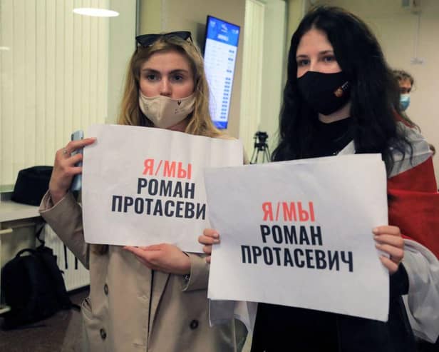 Women with posters reading 'I am/we are Roman Protasevich' in the arrival area as passengers disembark from the Ryanair passenger plane from Athens that was intercepted and diverted to Minsk on the same day by Belarus authorities on 23 May (Photo: PETRAS MALUKAS/AFP via Getty Images)