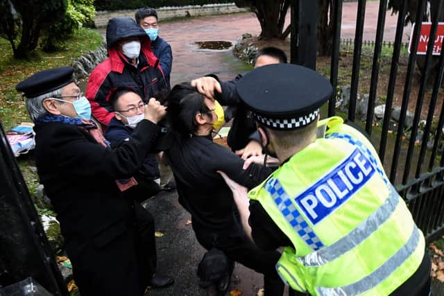 Police try to pull a Hong Kong pro-democracy protester out of the grounds of the Chinese consulate in Manchester. Picture: Matthew Leung/The Chaser News/AFP via Getty Images
