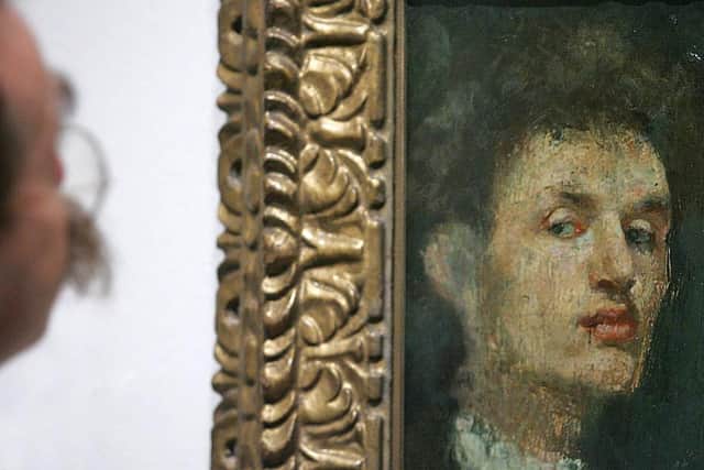 An art critic eyes Edvard Munch's 'Self portrait' in the Royal Academy of Arts in September 2005 (Photo: ODD ANDERSEN/AFP via Getty Images)