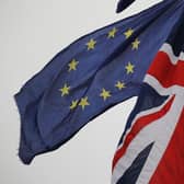 An EU Flag flown by an anti-Brexit protester is seen with a Union Flag set on a flag pole in Parliament sq1uare in front of the Houses of Parliament in London. Picture: Tolga Akmen/AFP via Getty Images