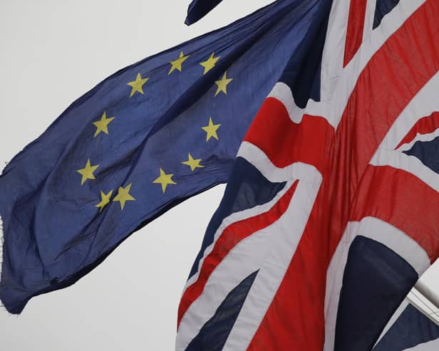 An EU Flag flown by an anti-Brexit protester is seen with a Union Flag set on a flag pole in Parliament sq1uare in front of the Houses of Parliament in London. Picture: Tolga Akmen/AFP via Getty Images