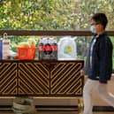 A resident walks in front of the food and daily necessities which be bartered by neighbours at an apartment lobby in a compound during lockdown in Pudong district in Shanghai.