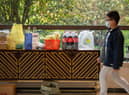 A resident walks in front of the food and daily necessities which be bartered by neighbours at an apartment lobby in a compound during lockdown in Pudong district in Shanghai.