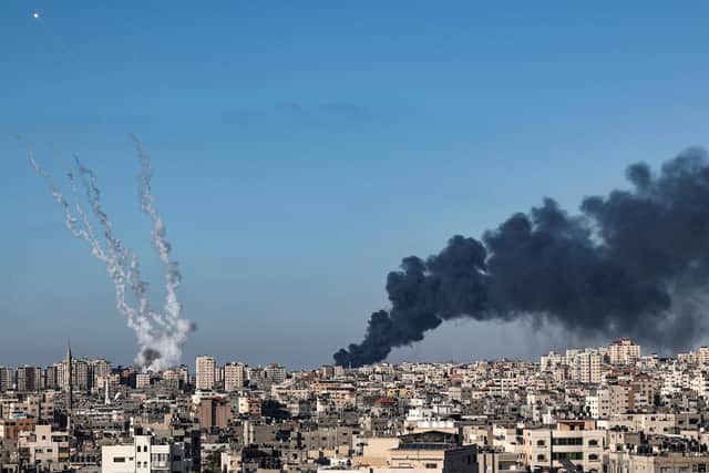 A plume of dark smoke rises above buildings hit by Israeli airstrikes in Gaza City,