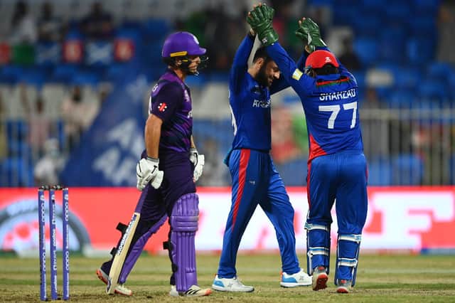 Rashid Khan of Afghanistan celebrates the wicket of Chris Greaves of Scotland with team-mate Mohammad Shahzad.