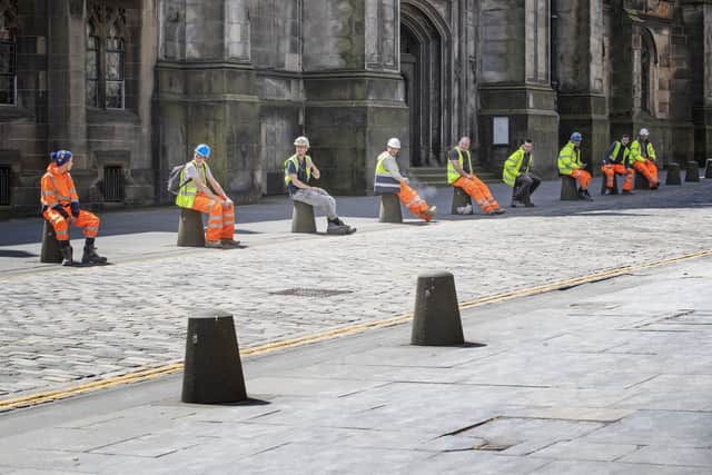 Construction workers comply with social distancing during their break along Edinburgh's Royal Mile as Scotland continues to lift coronavirus lockdown measures.