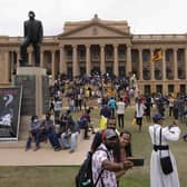 Protesters walk around and spend time at the ongoing protest site a day after storming into president's office in Colombo, Sri Lanka, Sunday, July 10, 2022. Sri Lankaâ€™s opposition political parties will meet Sunday to agree on a new government a day after the countryâ€™s president and prime minister offered to resign in the countryâ€™s most chaotic day in months of political turmoil, with protesters storming both officialsâ€™ homes and setting fire to one of the buildings in a rage over the nationâ€™s economic crisis. (AP Photo/Eranga Jayawardena)