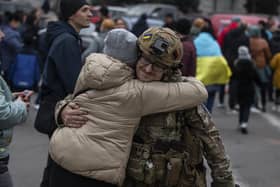 A woman hugs a Ukrainian officer as they celebrate the recapture of Kherson from Russian forces. Picture: AP