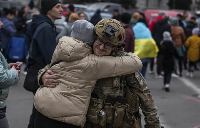 A woman hugs a Ukrainian officer as they celebrate the recapture of Kherson from Russian forces. Picture: AP