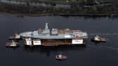 HMS Glasgow, the first of the new Type 26 frigates, sailing on a submergible barge being towed down the Clyde on her way to Geln Mallan on Loch Long. Picture: John Devlin.
