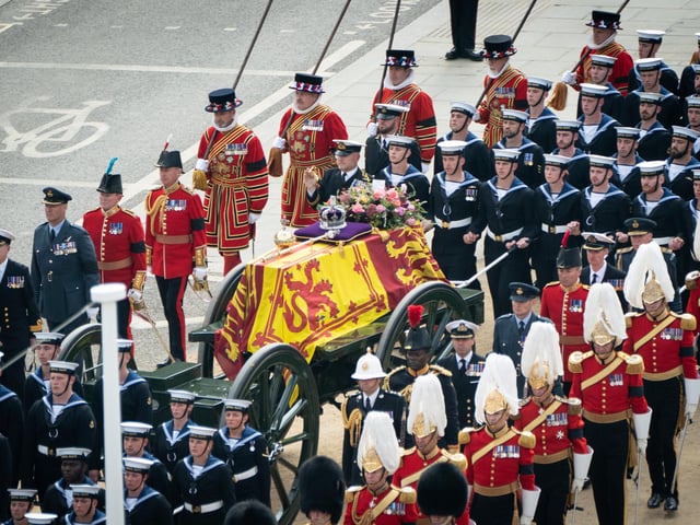 The State Gun Carriage carries the coffin of Queen Elizabeth II, draped in the Royal Standard with the Imperial State Crown and the Sovereign's orb and sceptre, as it leaves Westminster Abbey after the State Funeral of the Queen. Picture date: Monday September 19, 2022.